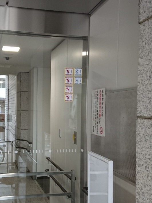 建築物出入口に貼り付けされた6枚のステッカーの写真
