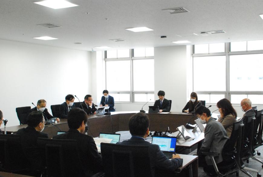 ロの字型に設置した机に委員が座り会議が行われている様子の写真