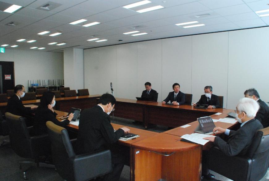 ロの字型の会議テーブルの席に関係者らが座り、総務常任委員会を行っている写真