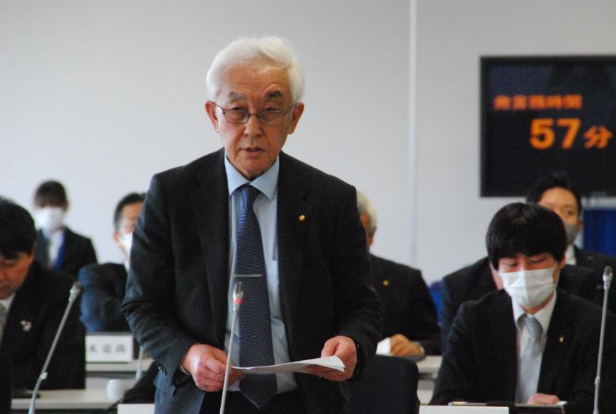 卓上マイクに向かい話をしている山田裕議員の写真
