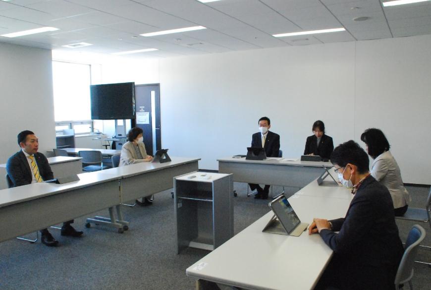 コの字型に配置されたテーブルで話をしている広報委員会の様子の写真