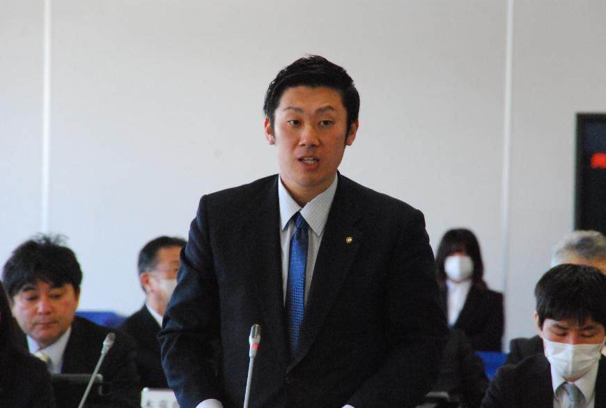 卓上マイクに向かって話をしている浦野洋太朗委員の写真