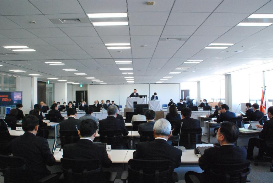 広い会議室で、50名ほどの関係者が席に座り、予算特別委員会を行っている写真