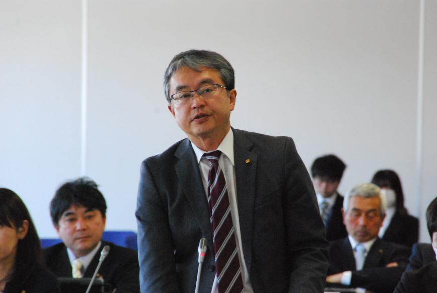 卓上マイクに向かって話をする川又康彦委員の写真