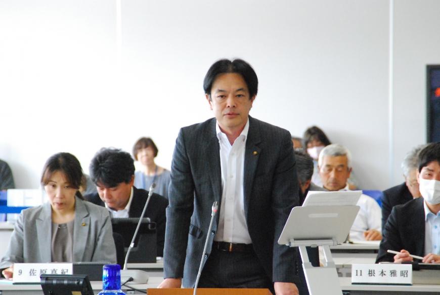 斎藤正臣議員が両手を台の上に置き登壇している写真