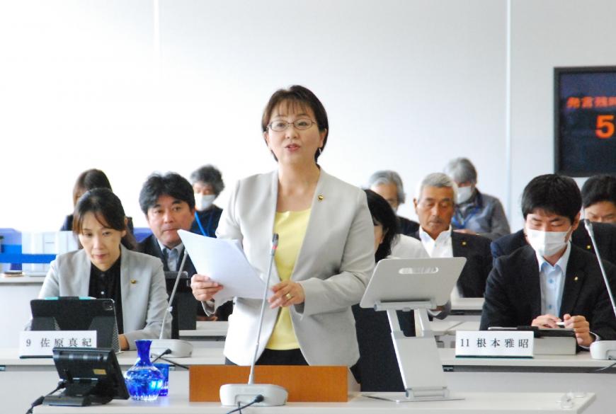 両手で資料を持った三浦由美子議員が登壇している写真