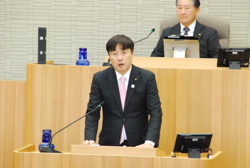 台の上に両手を置き真っすぐ前を向いて話をしている大平洋人議員の写真