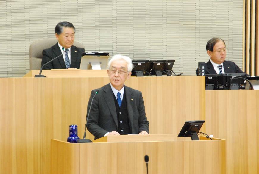 青いネクタイをつけた山田裕議員が右側を見ながら話しをしている写真