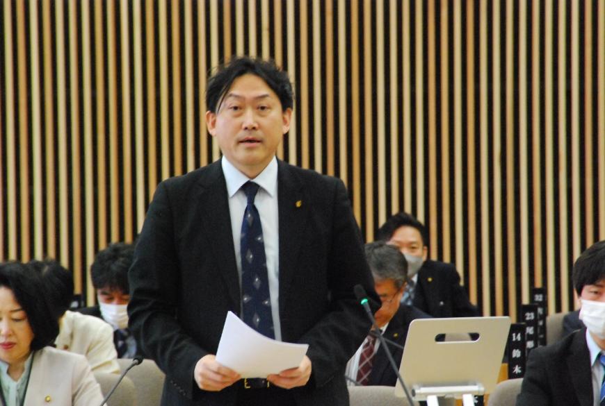 資料を両手で持ち真っすぐ前を向いて話をしている七島奈緒議員の写真