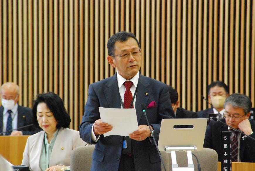 資料を両手で持ち顔を右側に傾けて話をしている宍戸一照議員の写真