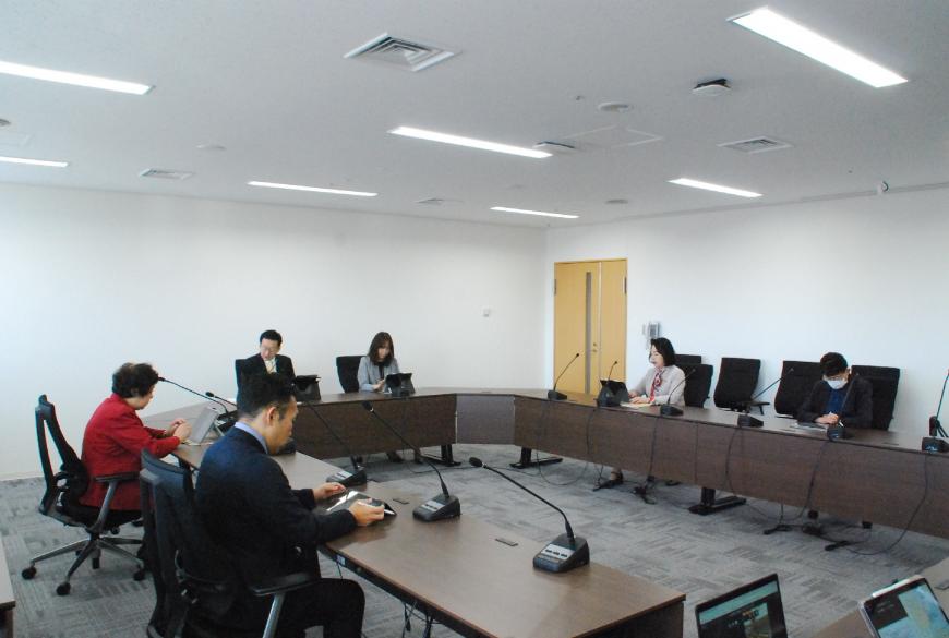 ロの字型に設置した長机の席に委員が座り広報委員会が行われている様子の写真