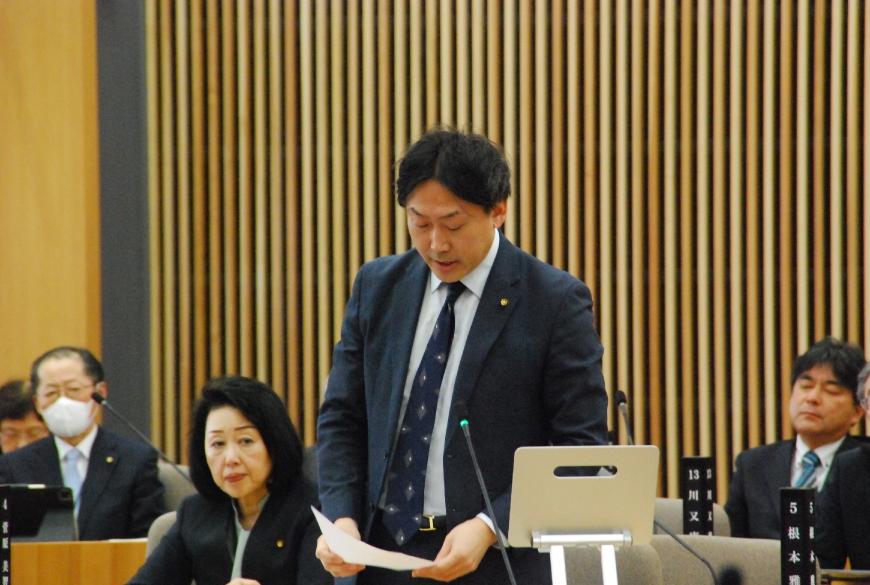 両手で持った資料を見ながら話しをしている七島奈緒委員の写真
