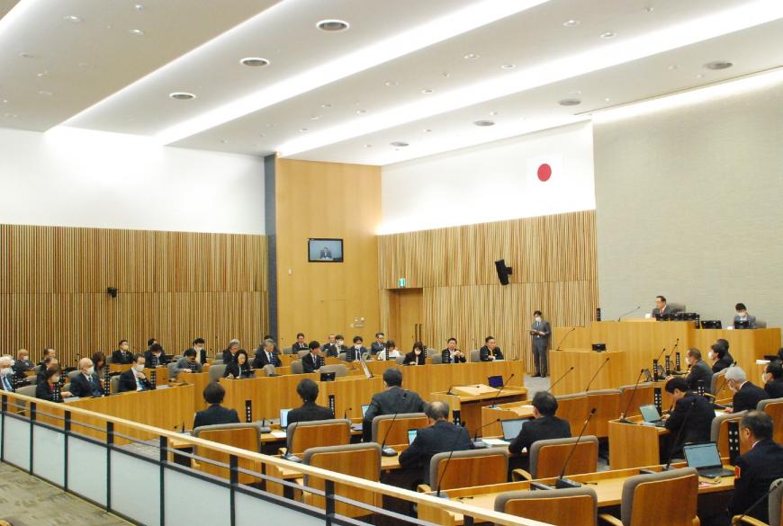 議場の自席に委員が座り予算特別委員会が行われている様子の写真