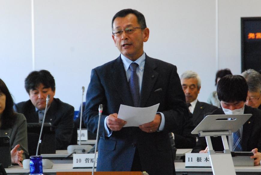 資料を両手で持ち右斜めを向いて話をしている宍戸一照議員の写真