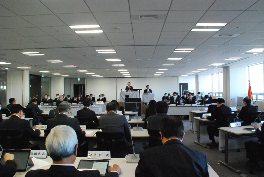 前方中央に委員長と副委員長が座り、左右と手前に設置された机に委員の方々が座り会議が行われている様子の写真
