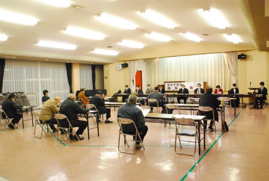 前方に設置された机と椅子に出席した議員の方が座り、議員席の前に2列に並べられた座席に参加者が座り意見交換会が開催されている写真