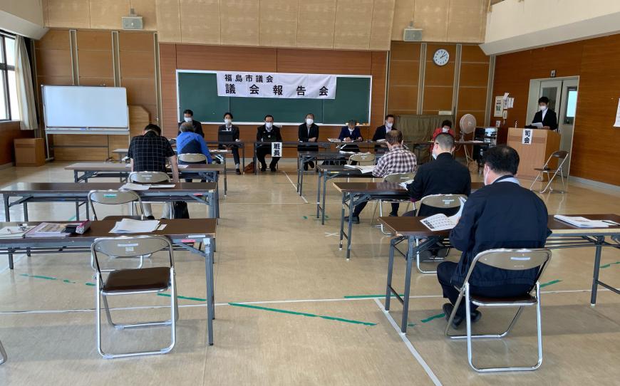 室内の前方に班長席が設置され、その前方に参加者の方々が座り資料に目を通している様子の写真