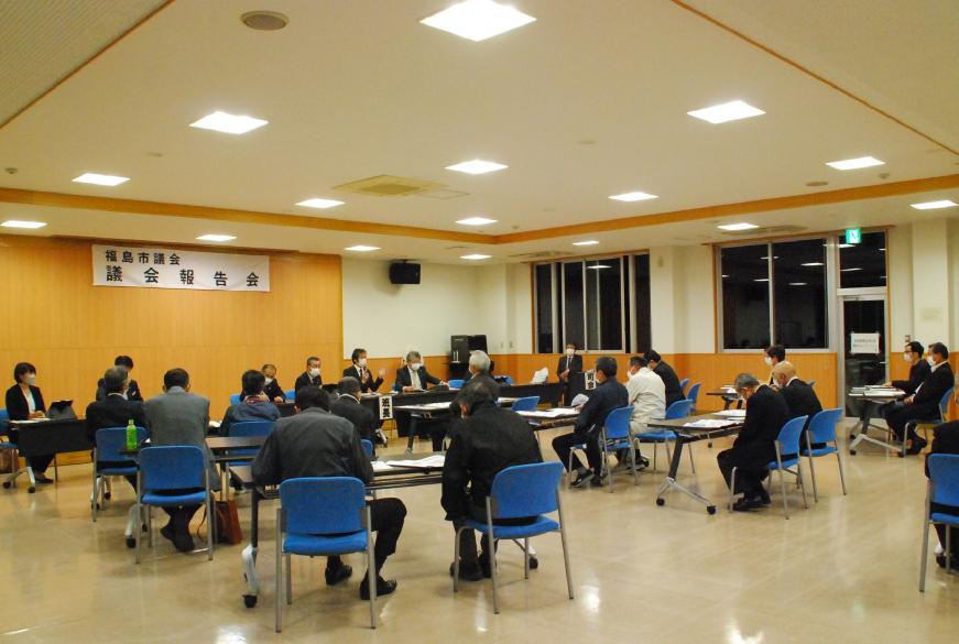関係者の方々が前方に設置された長机の前に座り、参加者の方々が会場内の席に着き意見交換会が行われている様子の写真