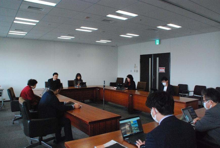 ロの字型の会議テーブルの席に関係者らが座っており、広報委員会が行われている写真