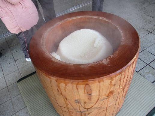 臼に入ったもち米から白い湯気が上がっている写真