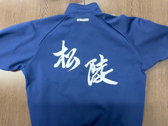 紺色のシャツの真ん中に白字で「杉陸」と書かれた運動着裏面の写真