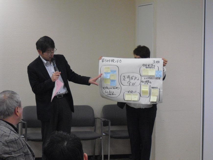 話し合いで出てきた意見を付箋に書き出し、その内容を男性が発表をしている写真