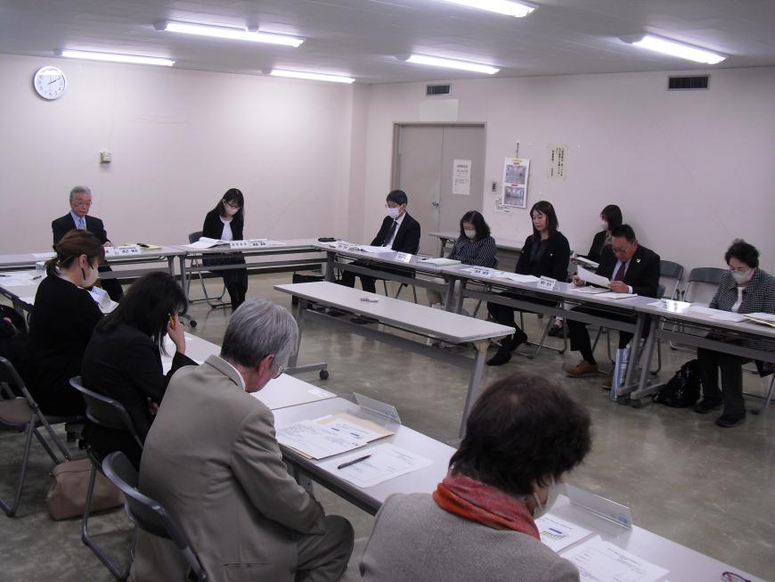 コの字型に配置されたテーブルと椅子に座り話をしているの会議の様子の写真