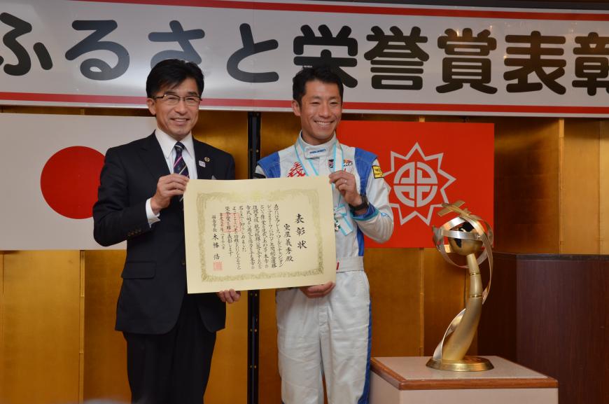 市長と室屋義秀氏が賞状を並んで持ち、笑顔で写っているふるさと栄誉賞表彰式の記念写真