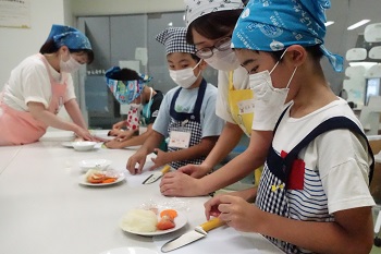 子どもたちが野菜を切る様子