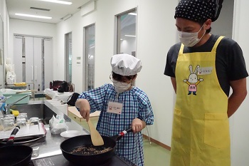 子どもが食材を炒める様子