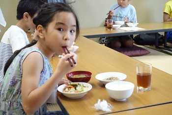 自分で作ったサラダを食べる子どもたち