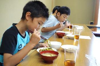 自分で作ったサラダを食べる子どもたち