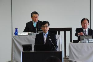 議会室で檀上に立つ市長が挨拶を行っている様子の写真