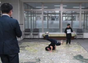 広い廊下で市長が見ているなか、2人の男の子がブレイキンを披露している写真