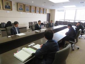 横長のテーブルを挟んで玉ノ井親方と2人の関係者が市長と向かい合って座り話をしている写真