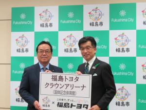 バックパネルの前で、「福島トヨタクラウンアリーナ」と書かれたボードを市長と男性で持っている写真