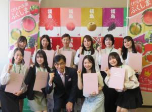 市長を中心に任命書を手にした女性10名が2列に並び右手でガッツポーズして撮影した写真