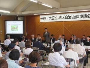 「笹谷・大笹生地区自治振興協議会」と書かれた横断幕の会場で参加している市民の前で、市長が立って話をしている写真