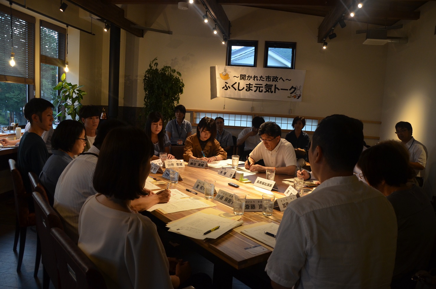 長方形の机に市長と市民の方々が座り、机に資料を広げ話をしている写真