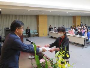 市長が女性に委託状を交付している様子を写した写真