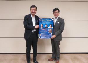 市長と太田社長が「三大テノールの夕べ」のポスターを持ち記念撮影をしている写真