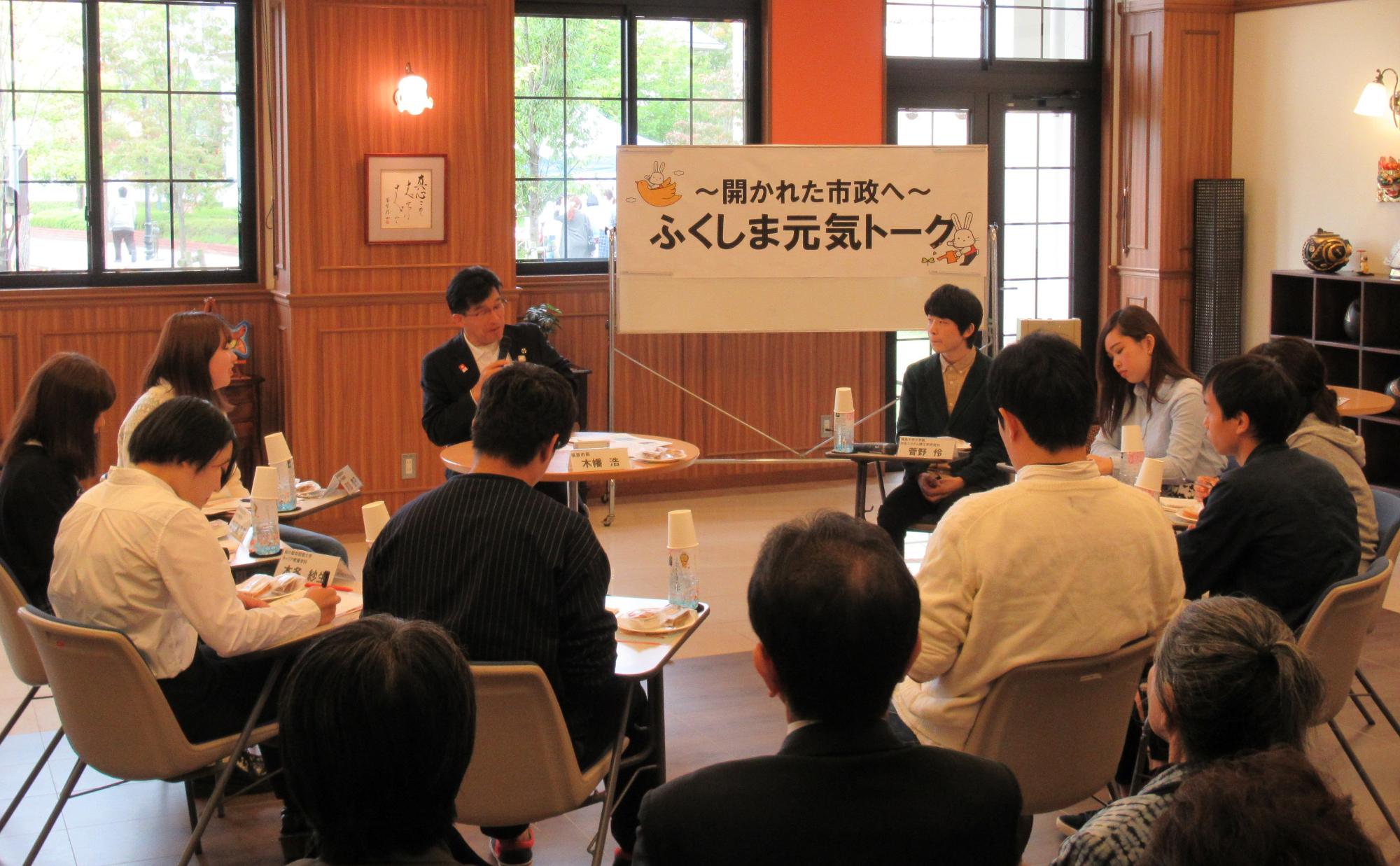 「~開かれた市政へ~福島元気トーク」と書かれたパネルが設置されており、市長と参加者が椅子を囲んで話をしている写真
