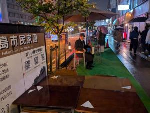 道路の片隅にテントと椅子が設置され、そこでくつろいでいる男性を写した写真