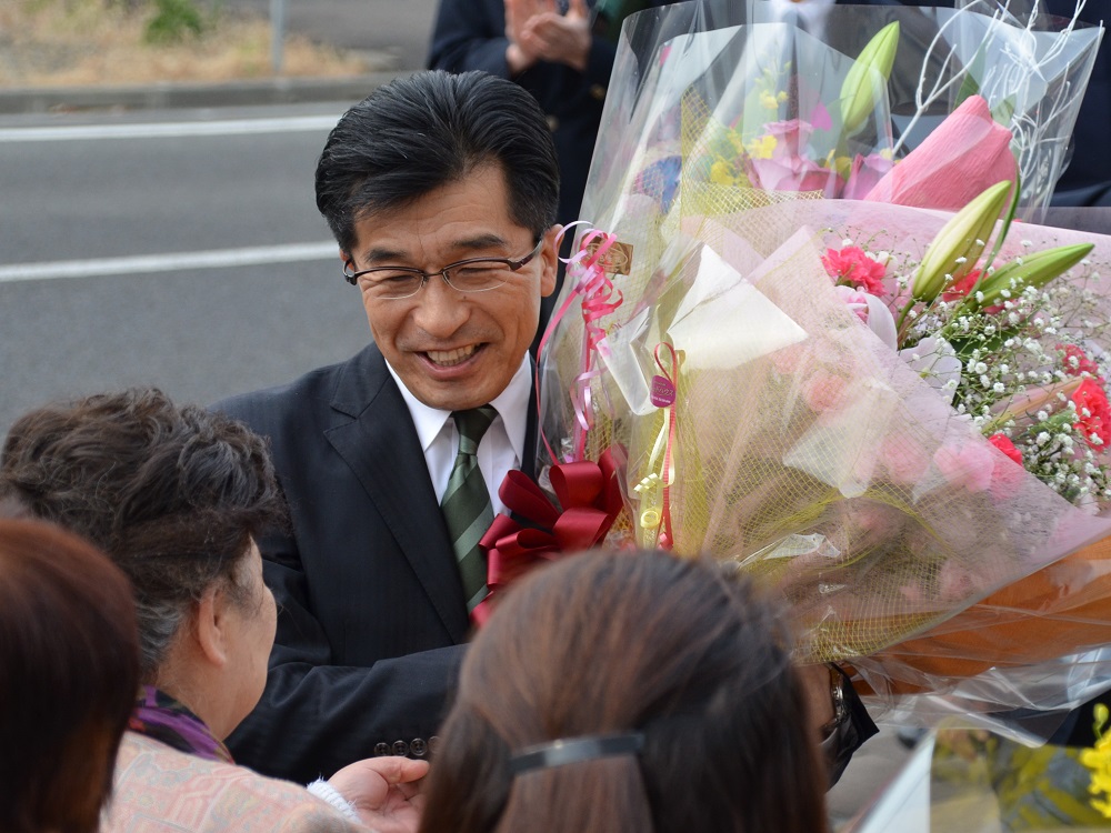 初登庁した市長が多くの花束を受け取っている写真