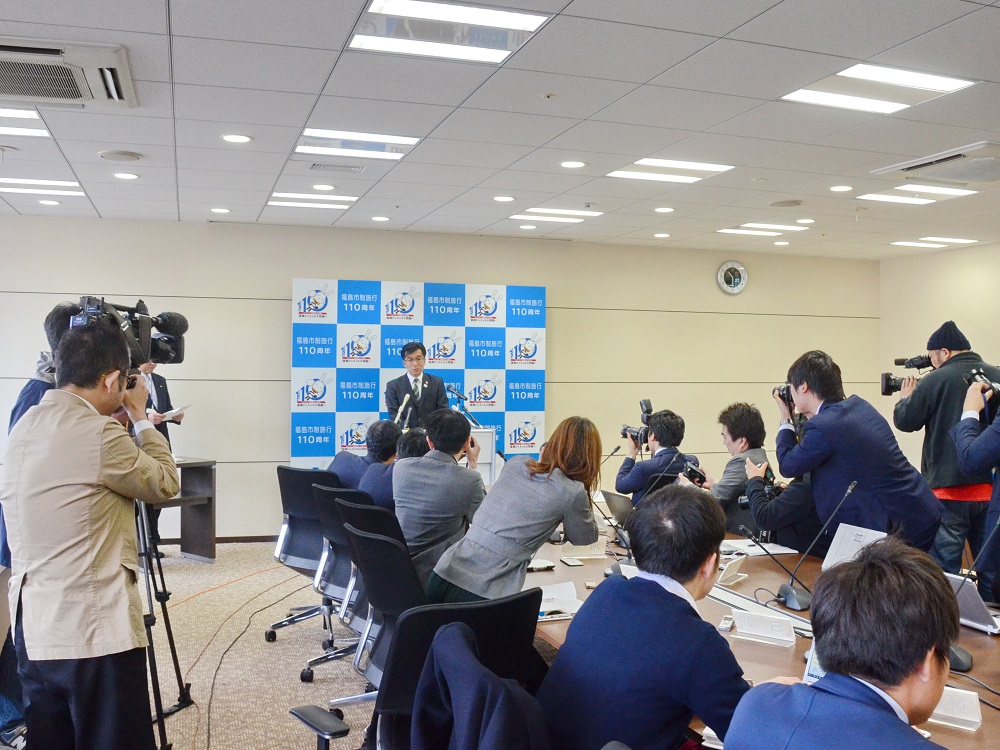 市長が話をしているところを多くの報道のカメラが撮影している写真