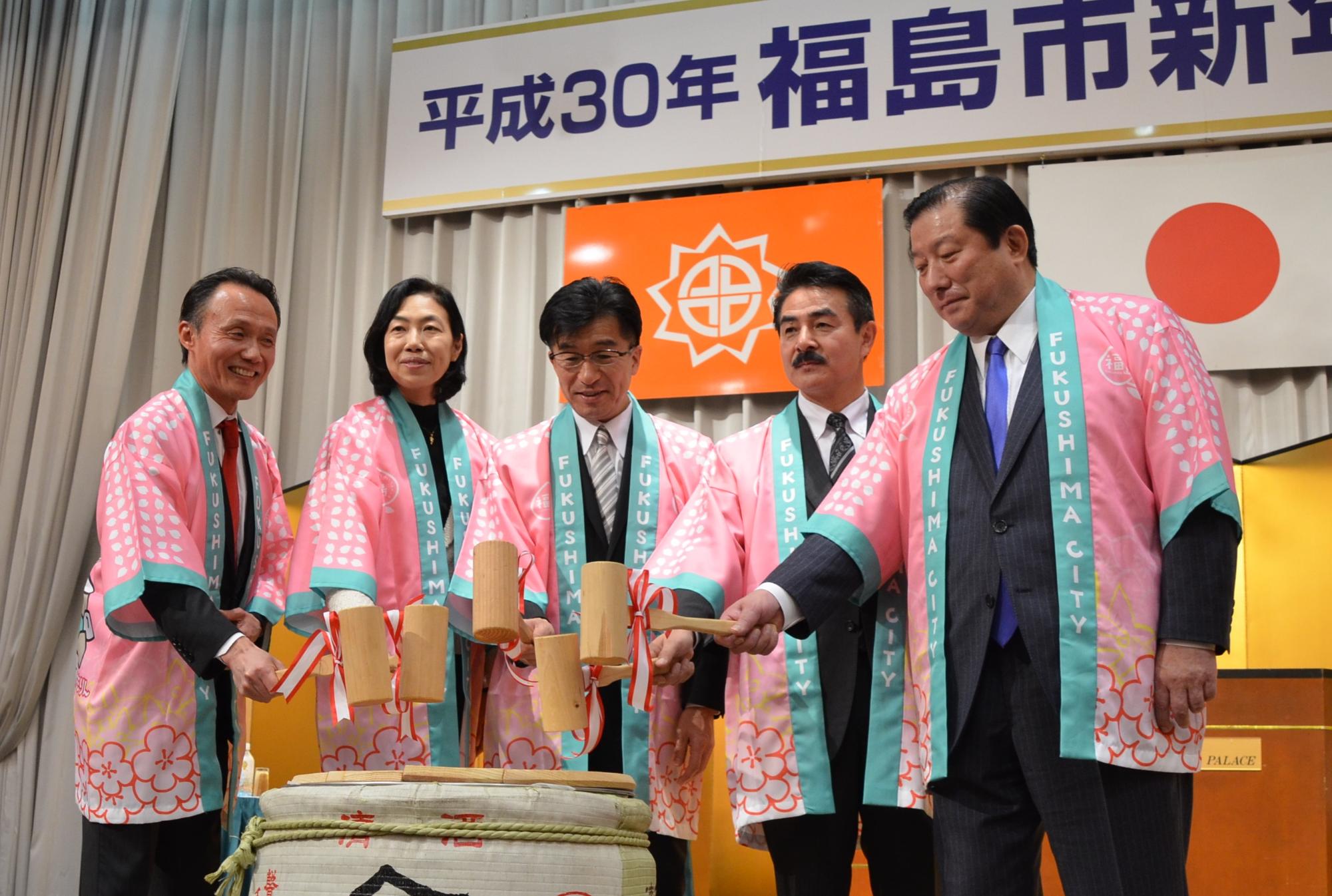 はっぴ姿の市長と関係者が木槌を手に持ち、鏡開きをしている写真