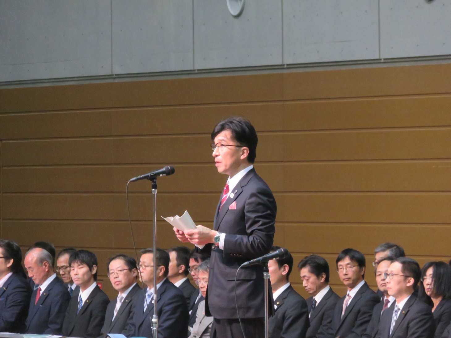 市長がマイクスタンドの前に立ち、祝辞を述べている写真
