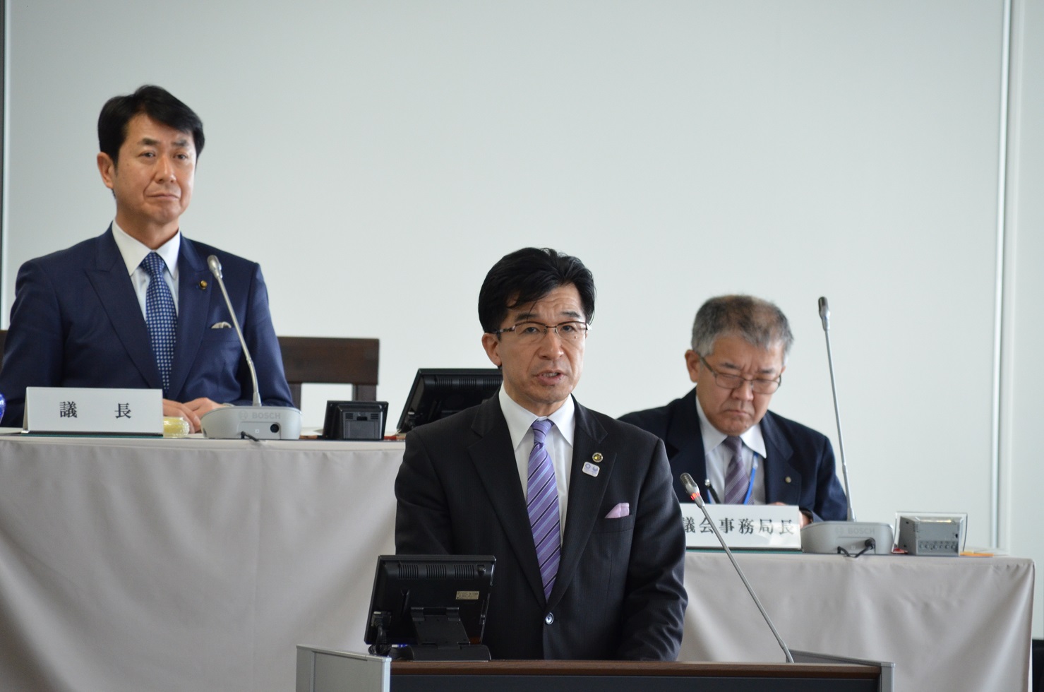 市議会室で、市長が演壇に立ち、発言をしている写真