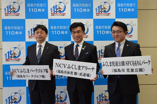 バックパネルの前で、市長と関係者が両手にそれぞれパネルを持っている写真
