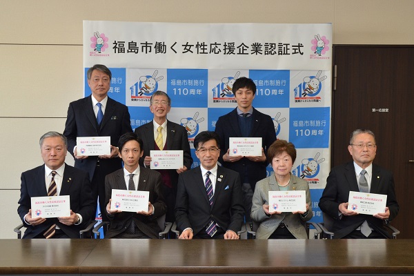 「福島市働く女性応援企業認定式」と書かれたバックパネルの前で、プレートを手に持った関係者と市長が2列に並んでいる写真